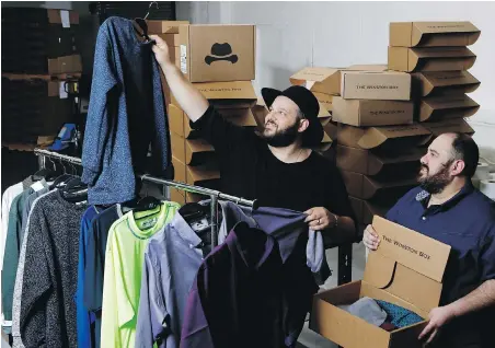 ??  ?? Co-owners Daniel Franzese, left, and Wil Cuadros select clothes for The Winston Box at their showroom in Gardena, California. The Winston Box is a monthly subscripti­on box with a collection of clothes for big guys.