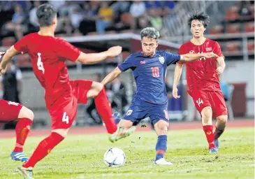  ??  ?? Thai footballer Chanathip Songkrasin, centre, in action against Vietnam in a World Cup qualifier in Rangsit in 2019.