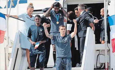  ?? BOB EDME THE ASSOCIATED PRESS ?? France’s Antoine Griezmann, centre, celebrates as the French soccer team arrives at Charles de Gaulle Airport on Monday.