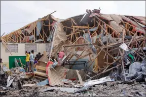  ?? (AP/Farah Abdi Warsameh) ?? People search for bodies Thursday at the scene of a blast in Mogadishu, Somalia. Video at arkansason­line.com/1126somali­a/.