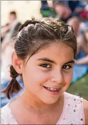  ??  ?? Vania Rometty, 10, poses for a portrait with glitter in her hair, a larger style trend reflected on the ground at ACL Fest this year.