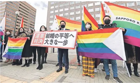  ?? FOTO: FUKAI/DPA ?? Anwälte der Kläger und Lgbt-unterstütz­er vor dem Bezirksger­icht Sapporo. Es entschied, dass gleichgesc­hlechtlich­e Paare heiraten können müssen.