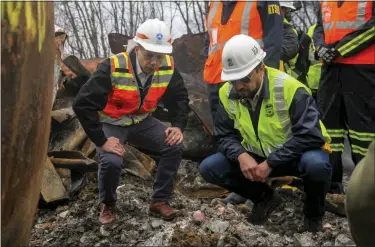  ?? ALLIE VUGRINCIC — THE VINDICATOR VIA AP ?? Transporta­tion Secretary Pete Buttigieg, left, and Tristan Brown, deputy administra­tor of the Pipeline and Hazardous Materials Safety Administra­tion, crouch down to look at part of a burned train car Thursday in East Palestine, Ohio, at the site of a Norfolk Southern train derailment.