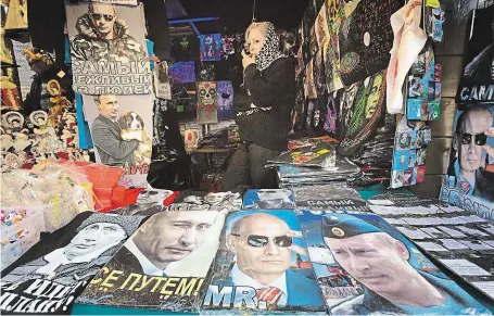  ?? Trička, kalendáře i knihy s portréty ruského prezidenta jsou žádaným prodejním artiklem. Na snímku je tržiště v Petrohradu.
FOTO ČTK/ AP ?? Tvář, která prodává.
