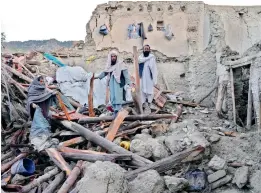  ?? AP/PTI ?? Afghans stand among destructio­n after an earthquake in Gayan village, in Paktika province of Afghanista­n, on Thursday. —