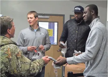  ?? PHOTO PROVIDED BY HENDRICKS ?? Keaton Hendricks, second from left, and teammates Vivian Aiken and Emmanuel Boateng hand out socks at Shalom Center in Bloomingto­n, Ind. Hendricks donated more than 4,000 socks.