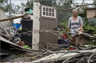  ?? ALEX WROBLEWSKI, GETTY IMAGES ?? A resident surveys the damage on her property after Maria made landfall, Thursday in a suburb of San Juan.