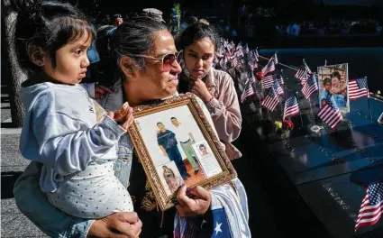  ?? Craig Ruttle / Associated Press ?? Julia Melendez holds a photo of her husband, Antonio, who died working at the Windows on the World restaurant on 9/11.