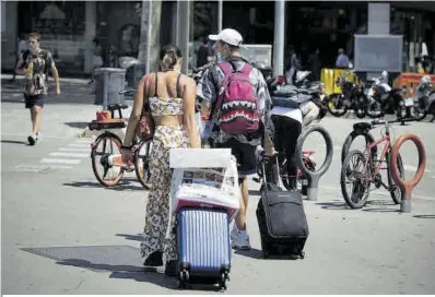  ?? Ferran Nadeu ?? Dos turistes porten maletes pel centre de Barcelona el juliol de l’any passat.