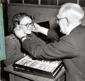  ??  ?? RIGHT: A patient is fitted with NHS spectacles at Moorfields Eye Hospital, London. The growing waiting list for glasses became a symbol of the system’s early travails