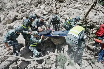  ??  ?? Chinese paramilita­ry police carry a survivor after an earthquake in Jiuzhaigou county, Ngawa prefecture, Sichuan province, China. — Reuters photo