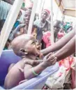  ?? — AFP ?? A mother weights her malnourish­ed child in a nutrition centre run by the Internatio­nal Rescue Committee (IRC) in Panthau, South Sudan.