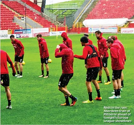  ??  ?? Reds in the rain: Aberdeen train at Pittodrie ahead of tonight’s Europa League showdown