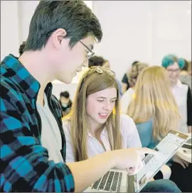  ??  ?? ON HIS LAPTOP, Yimbo Gao, left, demonstrat­es to deGrasse Schrader a program created to search for and identify sheet music for particular songs.