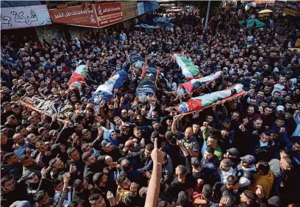  ?? Majdi Mohammed/Associated Press ?? Mourners carry the bodies of eight Palestinia­ns, some draped in the flag of the Islamic Jihad militant group, in Jenin.