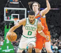  ?? Winslow Townson The Associated Press ?? Celtics forward Jayson Tatum drives against Thunder guard Josh Giddey in the first half of Boston’s victory Wednesday at TD Garden.