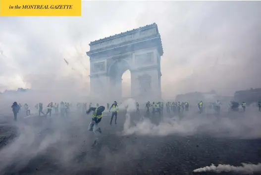  ?? VERONIQUE DE VIGUERIE / GETTY IMAGES ?? Tear gas surrounds “yellow vest” protesters as they clash with riot police Saturday near the Arc de Triomphe in Paris. Police said 133 people were injured and 412 arrested.