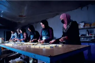  ?? ?? People work at a confection­ery factory in Mazar-i-Sharif, north Afghanista­n, on January 18