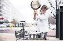  ?? PROVIDED / ATK] ?? Don't try this at home. To test cookware durability, America's Test Kitchen's Lisa McManus plunges searing hot pans into cold water to cause thermal shock then whack tests them outside on a concrete block to see how they hold up. [PHOTO
