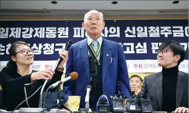  ?? KYODO NEWS VIA GETTY IMAGES ?? Plaintiff Lee Chun-sik (center) attends a news conference in Seoul on Tuesday, after the ROK Supreme Court ruled that Japan’s Nippon Steel &amp; Sumitomo Metal Corp compensate people for forced labor during Japanese colonial rule.