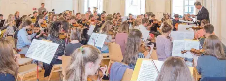  ?? FOTO: FRANK MÜLLER ?? Alban Beikircher (stehend, rechts) bereitet die Junge Philharmon­ie Oberschwab­en auf die Konzerttou­r vor.