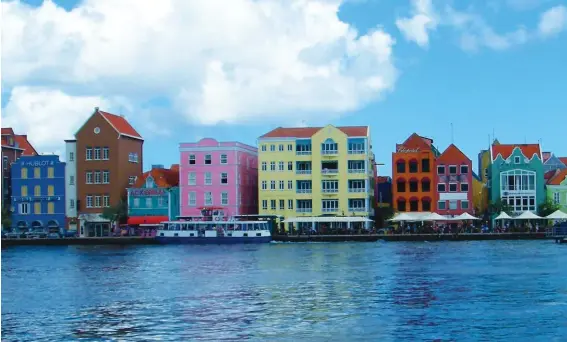  ??  ?? TOP: Colourful buildings along the water’s edge in Willemstad. RIGHT: Crumbling heritage can also be found in Willemstad. OPPOSITE PAGE: At Grote Knip beach, you can rent chairs and umbrellas and buy burgers and beer.