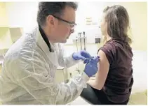  ?? TED S. WARREN/AP ?? Pharmacist Michael Witte gives Rebecca Sirull a shot. A Florida law that expands the treatments that pharmacist­s can provide may have run into a delay in implementa­tion after the state Board of Pharmacy announced its intention to add chronic conditions of heart disease and mental health.