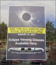  ??  ?? A poster advertisin­g the Aug. 21total solar eclipse hangs in the window of a McDonald’s restaurant in Madras, Oregon on June 12. The first place to experience total darkness as the moon passes between the sun and the Earth will be in Oregon and Madras,...