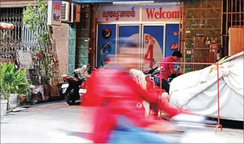  ?? SRENG MENG SRUN ?? A motorist passes the entrance to the 388 internet café in Phnom Penh yesterday.