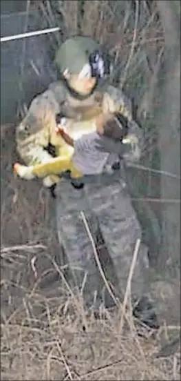  ??  ?? HEARTBREAK­ING: A member of the Texas Rangers cradles a 6-monthold girl last month after rescuing her from the Rio Grande, where she he had been tossed into the water from a raft by smugglers, according to the Texas Department of Public Safety, which released this photo on Tuesday.