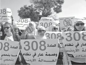  ?? REEM SAAD/THE ASSOCIATED PRESS ?? Female activists protest in front Jordan’s parliament in Amman on Tuesday with banners calling on legislator­s to repeal a provision that allows a rapist to escape punishment if he marries his victim.