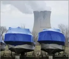  ?? JOHN SEEWER — THE ASSOCIATED PRESS ?? In this photo, boats wrapped and stored for winter sit near the Davis-Besse Nuclear Power Station along Lake Erie in Oak Harbor, Ohio. FirstEnerg­y Corp. will decide by next year whether to close or sell its plant in Pennsylvan­ia and two in Ohio,...