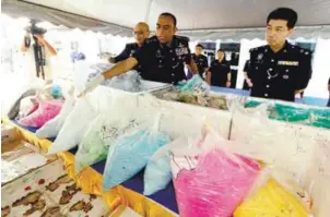  ??  ?? Mohd Khalil (centre) showing the bags of drugs to be destroyed.