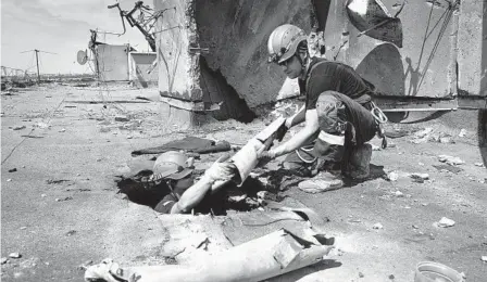  ?? SOFIIA BOBOK AP ?? Ukrainian rescuers search for and retrieve the remains of Russian shells on the roof of a high-rise building damaged by Russian shelling in one of the residentia­l areas of Kharkiv, Ukraine, on Thursday.