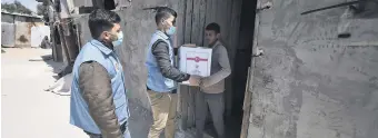  ??  ?? Volunteers from a local NGO supported by Turkish Diyanet Foundation (TDV) delivers a Ramadan aid package to a family in the Gaza Strip, Palestinia­n territorie­s, April 12, 2021.