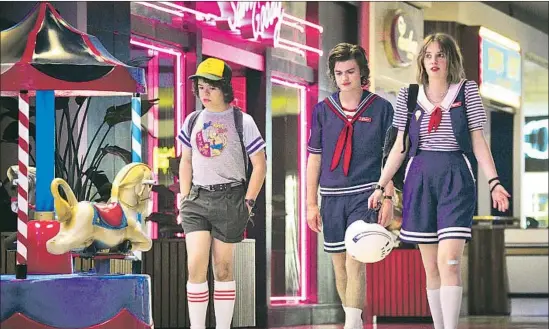  ?? Netf lix ?? DUSTIN (Gaten Matarazzo, left), Steve (Joe Keery) and Robin (Maya Hawke) stroll through Starcourt Mall, a temple to 1980s consumeris­m, in “Stranger Things 3.”