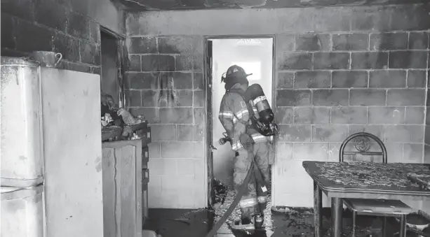  ?? FOTO: CORTESÍA ?? >Un elemento de Bomberos ingresa a la vivienda para sofocar el fuego.