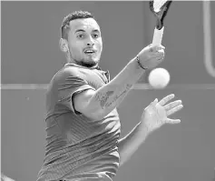  ??  ?? Kyrgios returns to Donald Young of the US in their men’s singles 1st round match at the ATP Aegon Championsh­ips tennis tournament at Queen’s Club in west London. — AFP photo