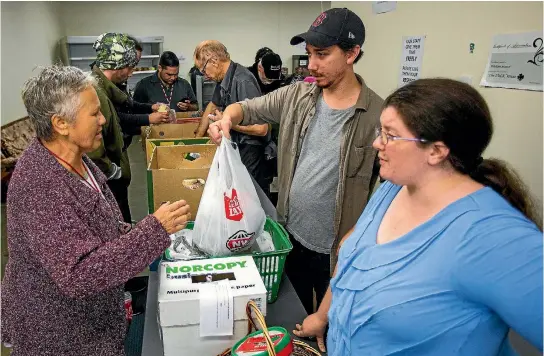  ?? PHOTO: DAVID UNWIN/FAIRFAX NZ ?? Just Zilch store manager Ben Sutherland and founder Rebecca Culver help distribute food to some of the hundreds of people visiting daily.