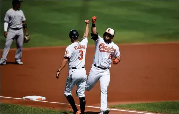  ?? AP PHOTO BY GAIL BURTON ?? Baltimore Orioles’ DJ Stewart, right, is congratula­ted by third base coach Jose Flores after hitting a two-run home run against the New York Yankees in the first inning of a a baseball game, Sunday, Sept. 6, 2020, in Baltimore, Md.