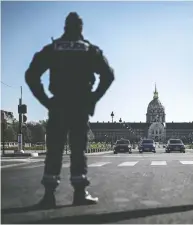  ?? PHILIPPE LOPEZ / AFP VIA GETTY IMAGES ?? A police officer stands waiting to control people in Paris on Tuesday, which was the eighth day of a lockdown
aimed at curbing the spread of the coronaviru­s.