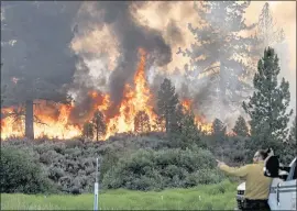  ?? NOAH BERGER — THE ASSOCIATED PRESS ?? Firefighte­r Kyle Jacobson monitors the Sugar fire, part of the Beckwourth Complex fire, burning in Plumas National Forest on Friday.