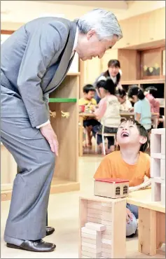  ??  ?? Akihito talks with a boy during a visit to Yakumo nursery school in Tokyo.