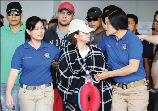  ??  ?? FOR FURTHER INVESTIGAT­ION – Ozamiz City Vice Mayor Nova Princess Parojinog-Echavez (in white cap) and her brother Reynaldo Parojinog Jr. (in red cap) are escorted out of the Ninoy Aquino Internatio­nal Airport (NAIA) Terminal 3, Monday, on their arrival...