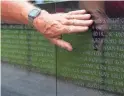  ??  ?? Vietnam Army veteran Max Cox runs his hand along his friend Chester A. Wright’s name on the Vietnam Memorial Wall in Washington.