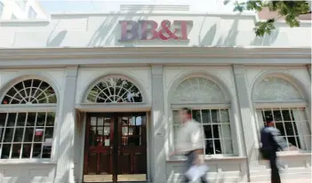  ?? — Reuters ?? People walk past a BB&amp;T bank in Alexandria, Virginia, US.