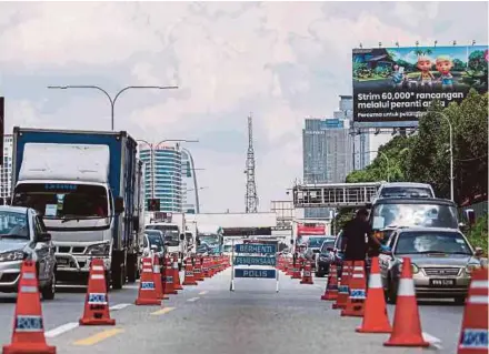  ?? (Foto Azhar Ramli/bh) ?? Anggota polis membuat sekatan jalan raya di Lebuhraya Persekutua­n, Kuala Lumpur bagi menyekat pergerakan rentas daerah dan negeri tanpa kebenaran, semalam.