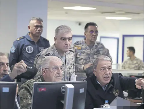  ?? ?? ↑ Turkey’s defence minister Hulusi Akar, right, chairs a new air operation in northern regions of Iraq and Syria