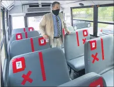  ?? DAVID CRIGGER/BRISTOL HERALD COURIER VIA AP ?? Superinten­dent Dr. Keith Perrigan shows the new seating configurat­ion on the school buses for the upcoming school year, Thursday, July 16, in Bristol, Va. A maximun of 22 students can be on the bus.