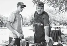  ?? Darren Abate ?? Brian Kempker, right, and son Brandon, 14, prepare spare ribs for a brown sugar rub at Pickrell Park in Schertz.